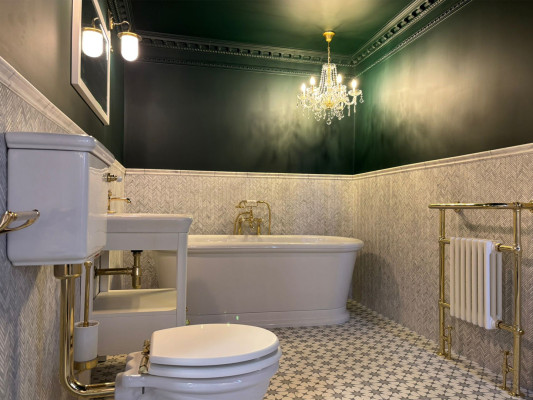 Elegant bathroom featuring a chandelier above a luxurious bathtub